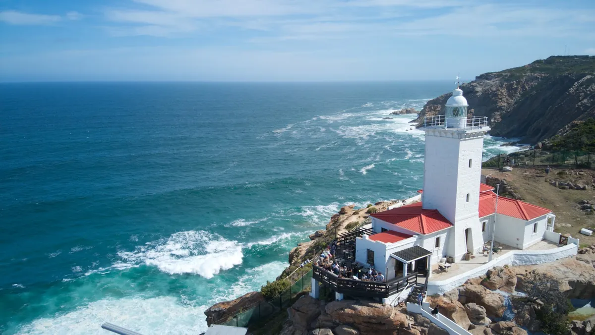 Cape St Blaize Lighthouse — the white tower with its red roof on the rocky headland above the Indian Ocean at Mossel Bay