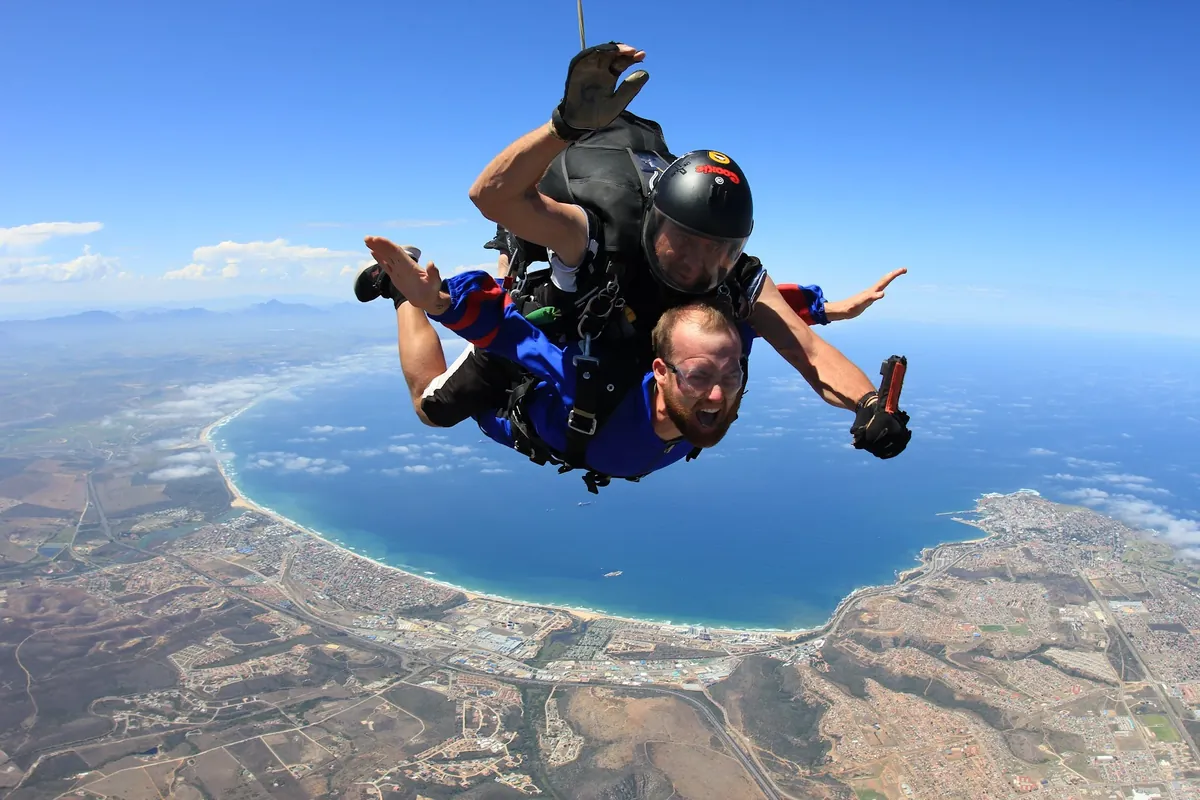 Tandem skydiver in freefall high above the Mossel Bay coastline and bay