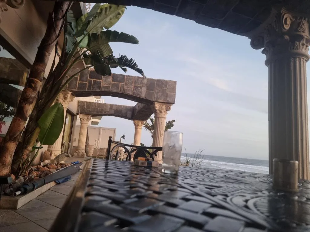 Covered beachfront deck with ornate columns and ocean view