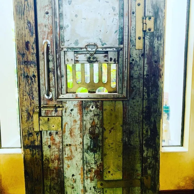 Weathered wooden door with vintage brass hardware and small window panes