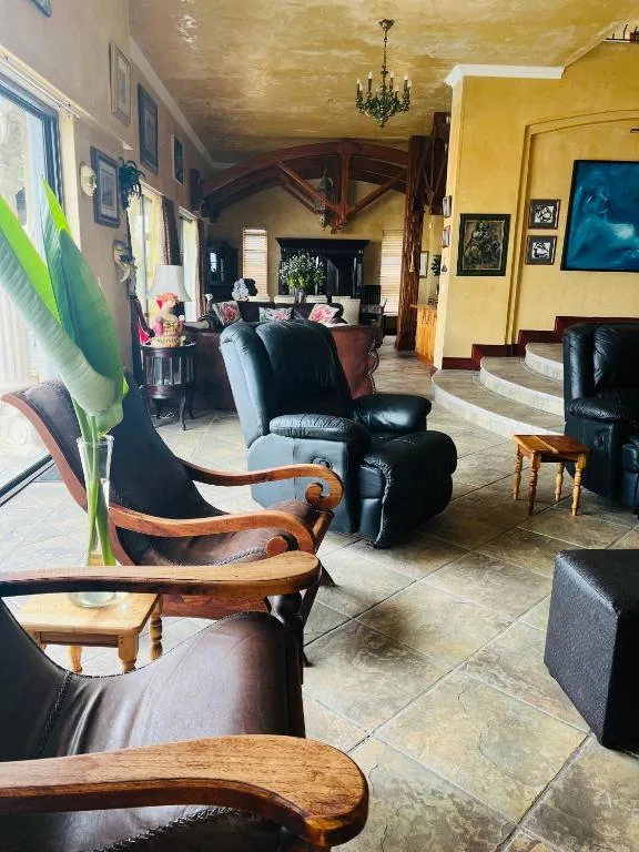 Spacious lounge with black leather armchairs and wooden accents throughout