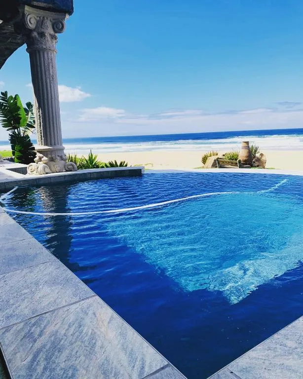 Infinity pool overlooking pristine beach and ocean waters