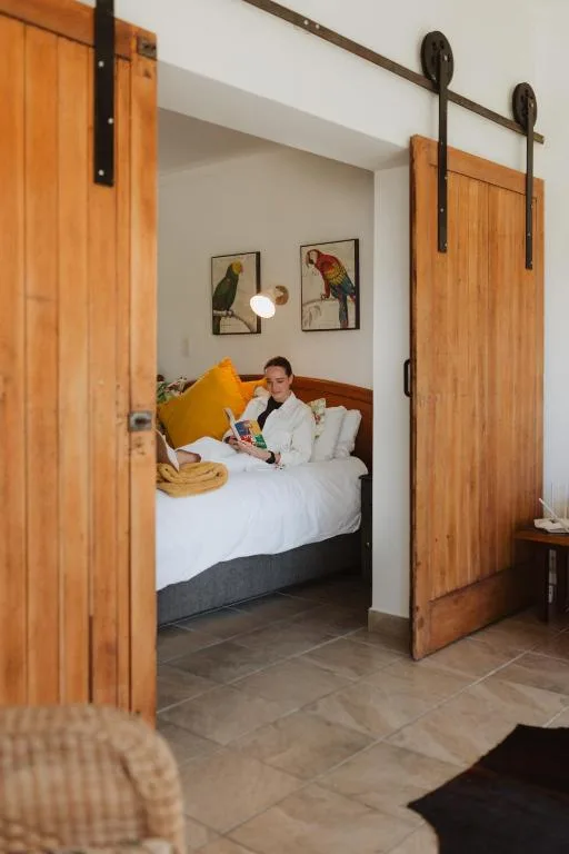 Spacious bedroom with wooden sliding doors, white bedding, yellow accent pillow