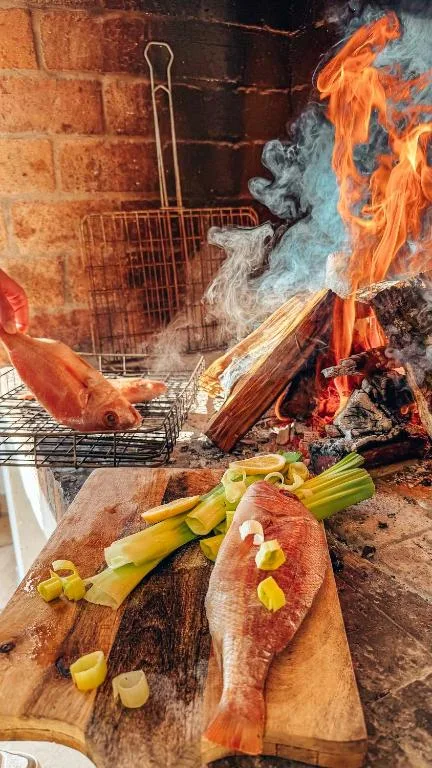 Fresh fish and vegetables prepared over open fire at outdoor braai area