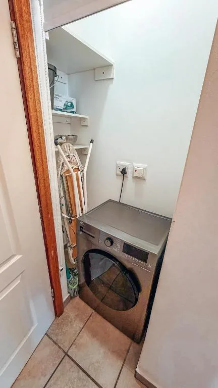 Compact laundry room with washing machine and storage shelves