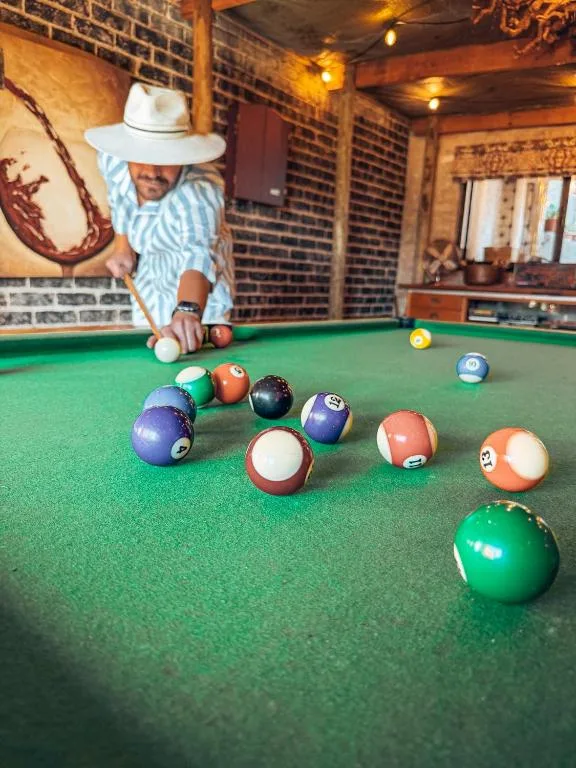 Person playing pool at a felt table with colorful balls