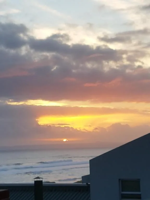 Stunning sunset over the ocean with dramatic cloudy sky and golden light