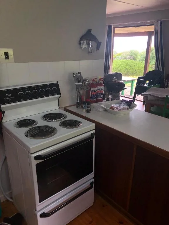 White electric stove with four burners in compact kitchen area