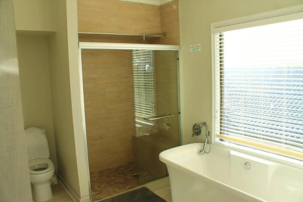 Modern bathroom with walk-in shower, freestanding bathtub, and ocean views