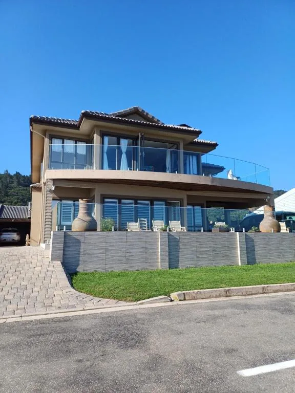 Modern two-story house with large windows and manicured garden on quiet street