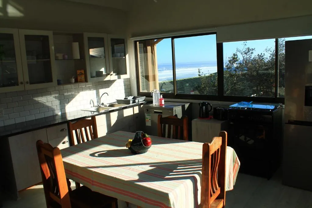 Open-plan kitchen and dining area with ocean views through large windows