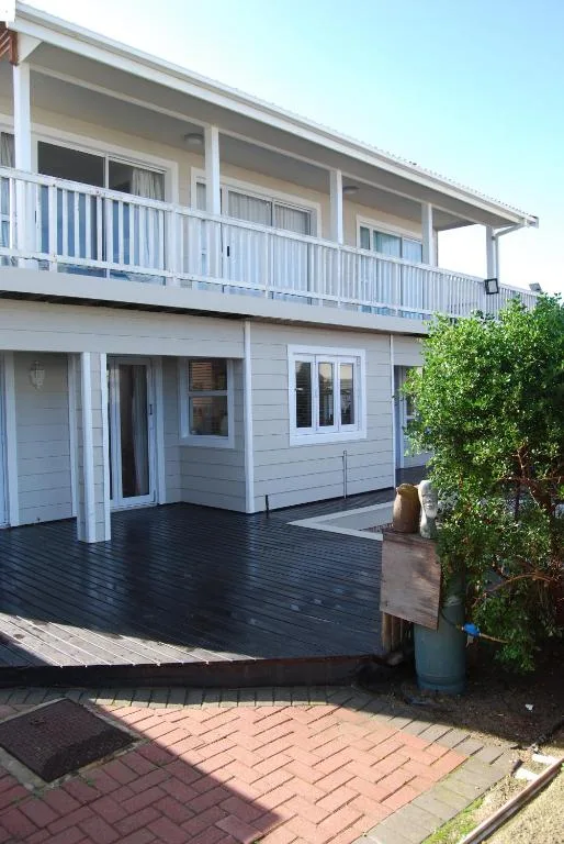 Modern two-story house with white railings and dark timber deck