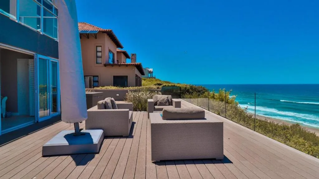 Oceanview deck with outdoor seating overlooking turquoise beach waters