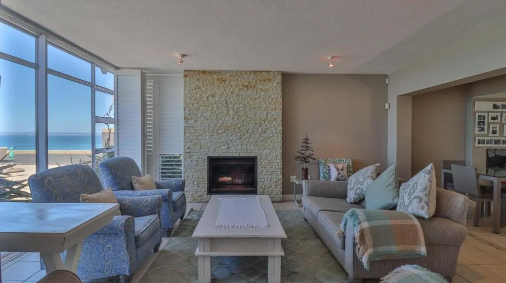 Spacious lounge with fireplace, ocean views, and comfortable seating