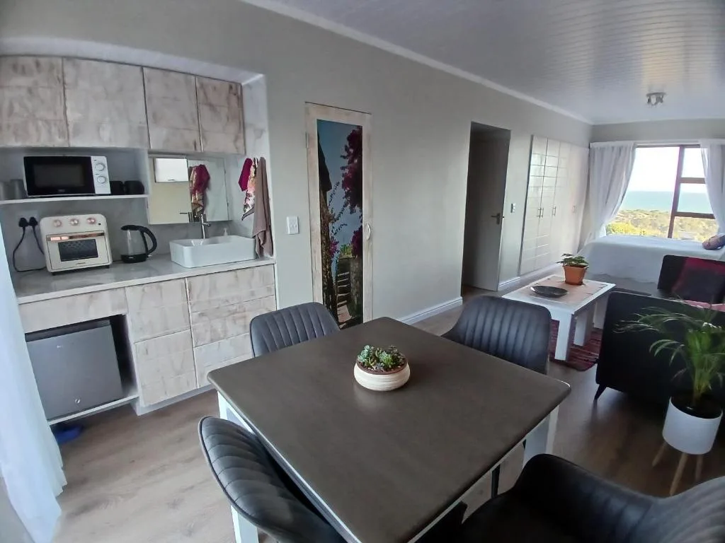 Modern dining table with black chairs in open-plan kitchen and lounge space
