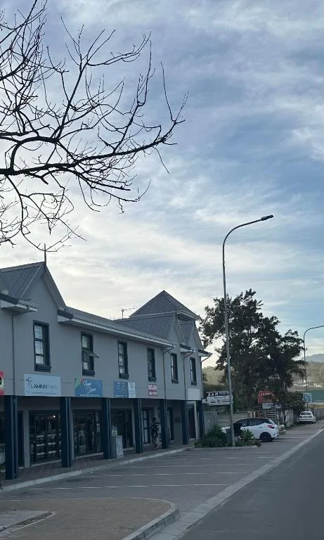 Street-facing facade of historic building with shops below, mountains visible