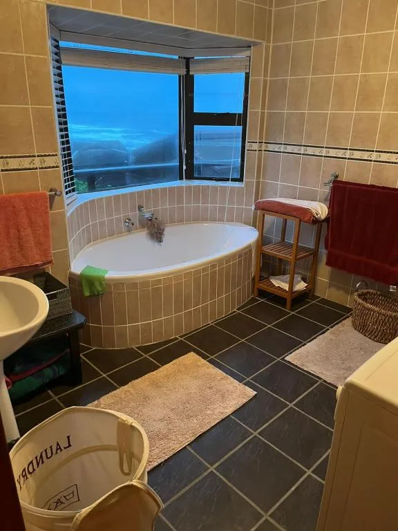 Spacious bathroom with corner soaking tub and scenic water views