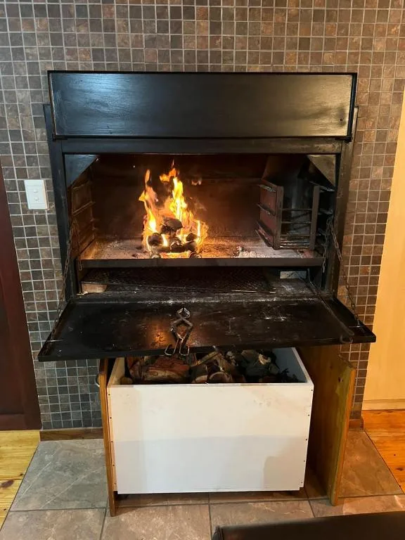 Active fireplace with burning logs in modern black metal frame insert