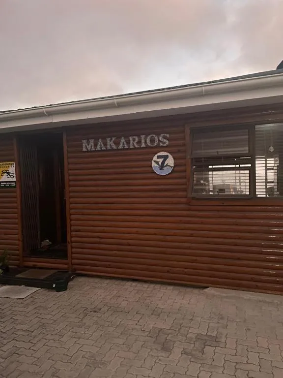 Wooden cabin exterior with Makarios signage and entrance door