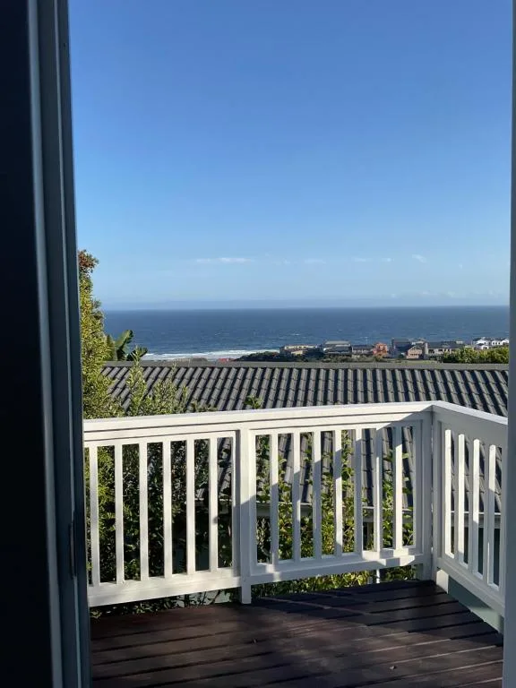 Ocean and coastal town vista from elevated deck with white railings