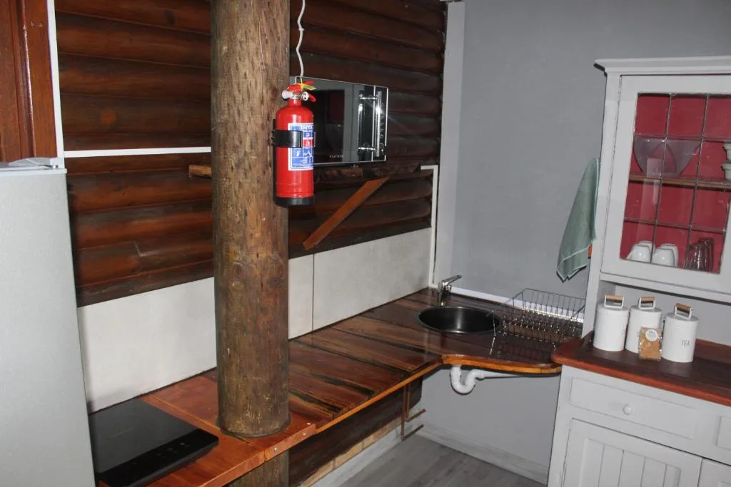 Modern kitchen area with wooden support post and fire extinguisher mounted on wall