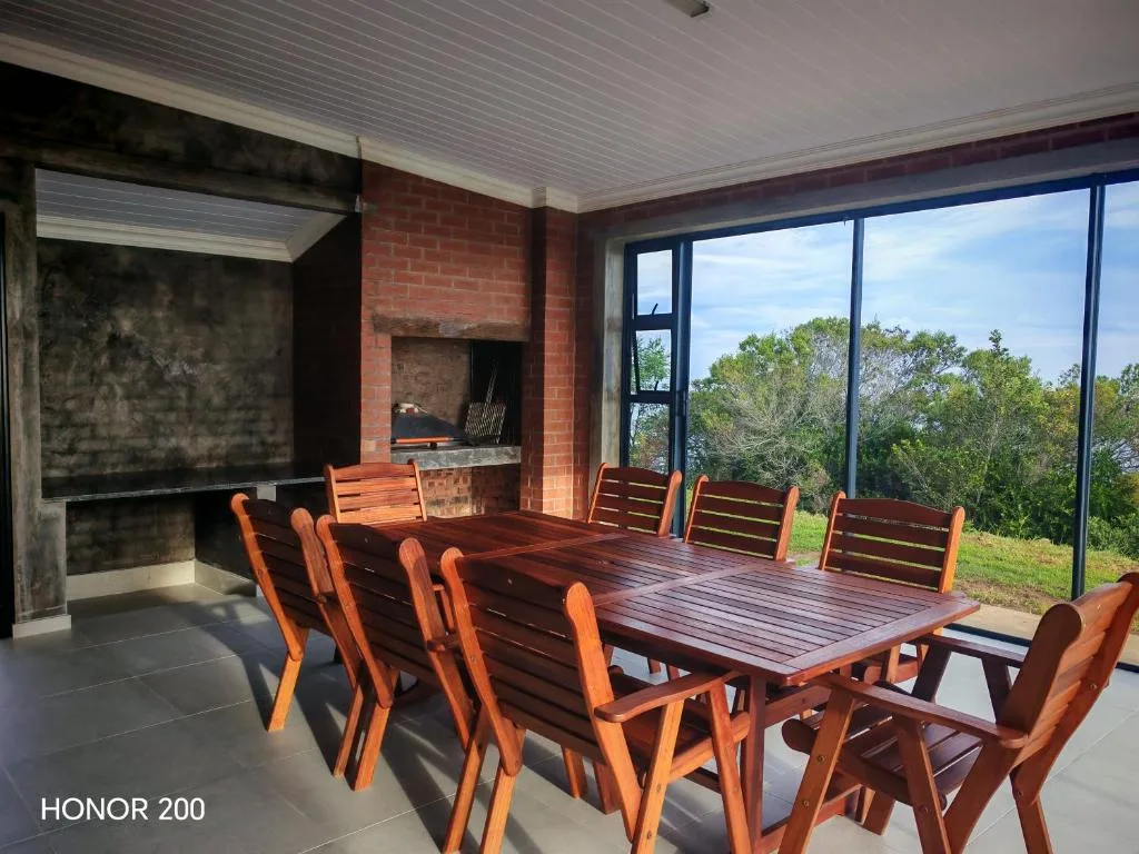 Indoor entertainment deck with dining table and scenic garden views through glass doors