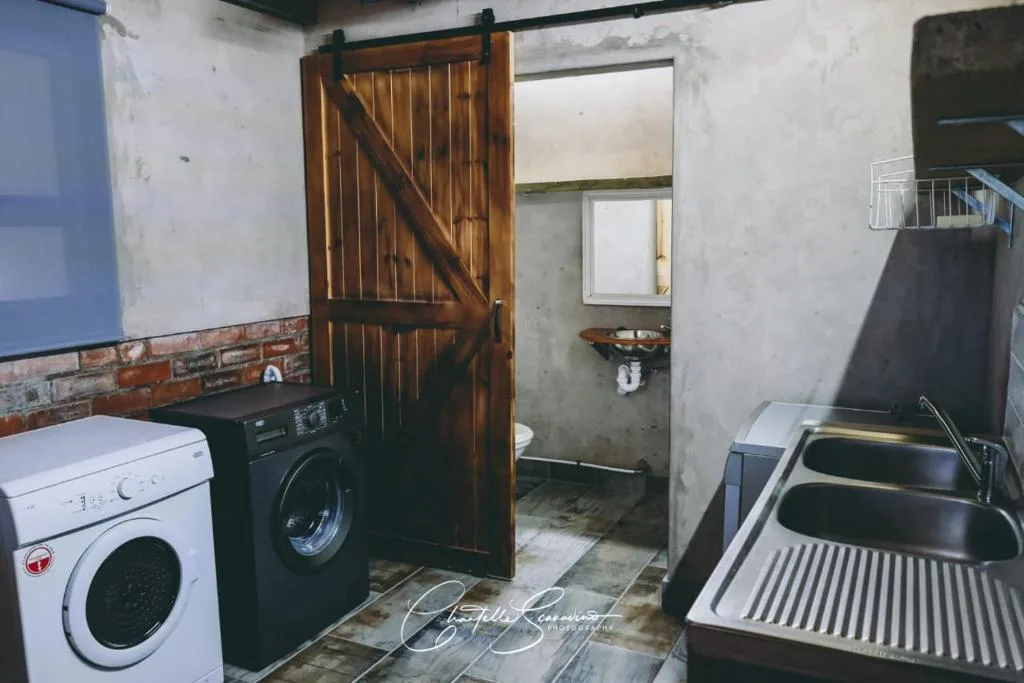 Rustic laundry and utility area with washing machines and sink