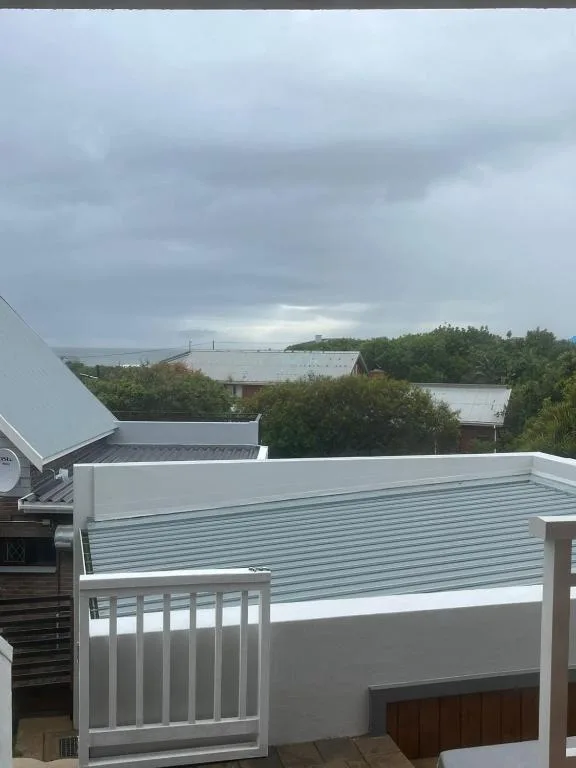 Lagoon and forested shoreline view from elevated deck with white railings