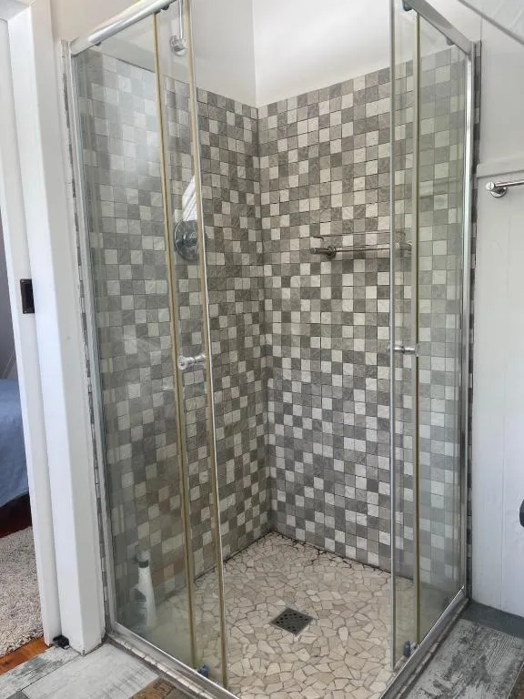 Modern corner shower enclosure with geometric tiled walls and floor
