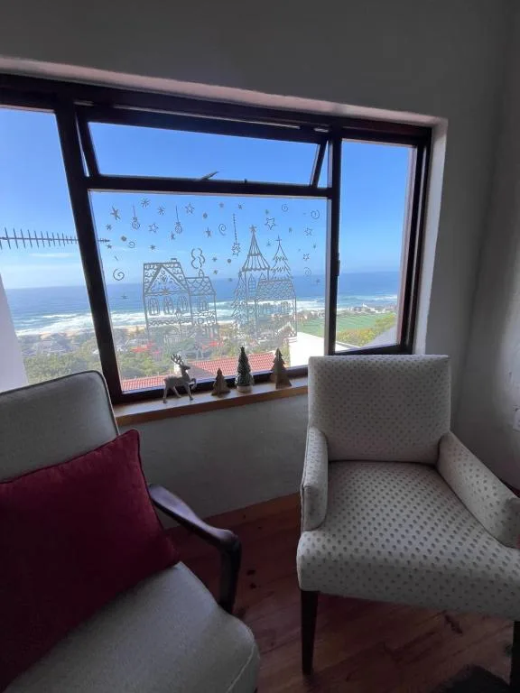 Panoramic ocean and coastal landscape vista through large windows from apartment