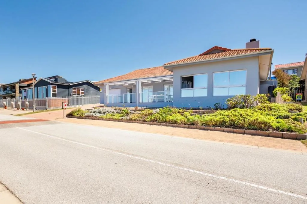 Modern white holiday home with large windows and terracotta roof tiles
