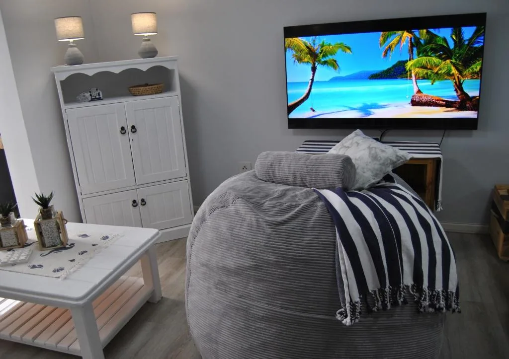 Modern bedroom with bed, TV, storage cabinet, and coastal decor accents