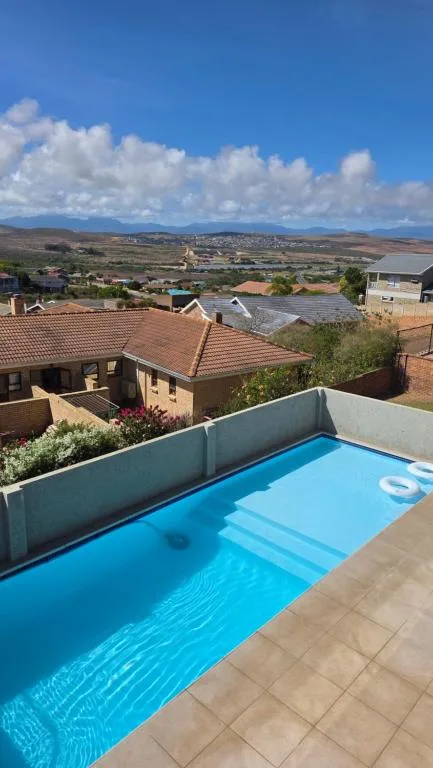Bright blue swimming pool with countryside and mountain views beyond