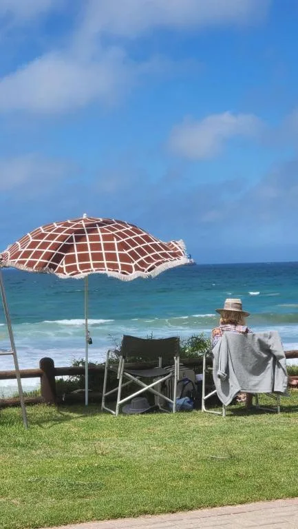 Beachfront view with umbrella, loungers, and turquoise ocean