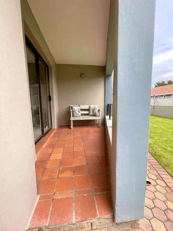 Covered patio with terracotta tiles and white bench seating area