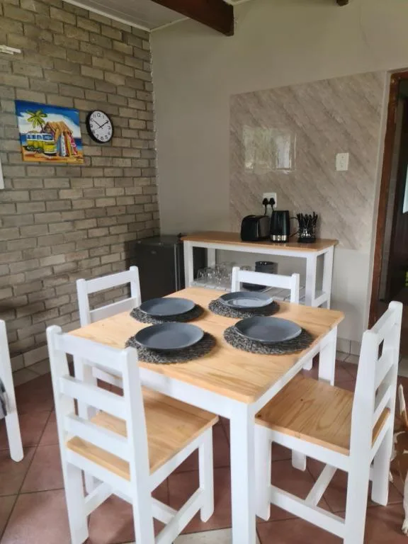 Dining table with white chairs and place settings in kitchen area