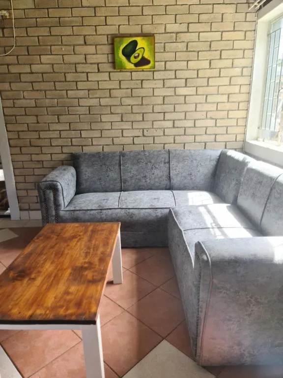 Gray sectional sofa with wooden coffee table in bright brick lounge