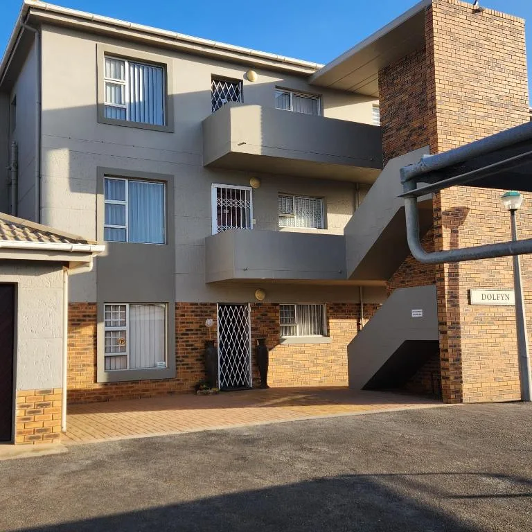 Modern multi-story residential building with brick and rendered facade, driveway entrance