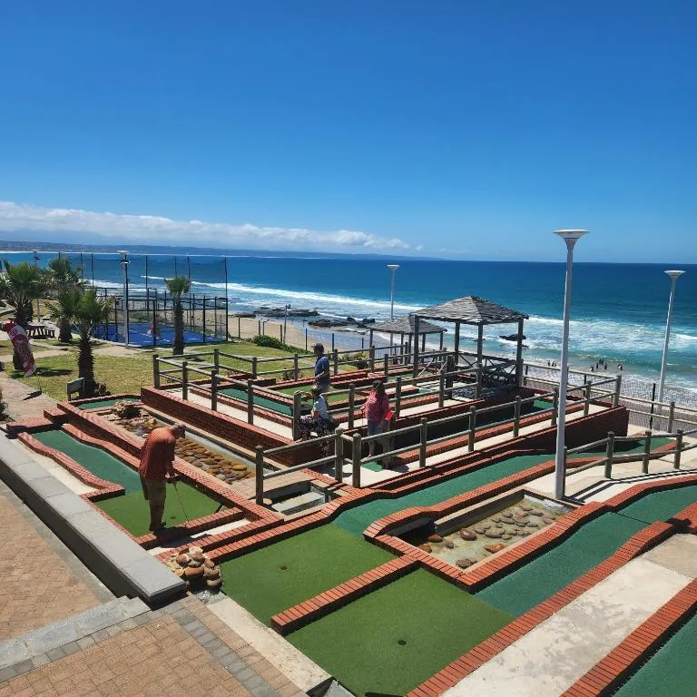 Scenic ocean and beach view with mini golf course in foreground