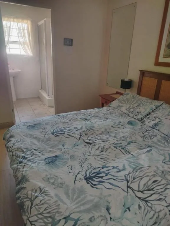 Bedroom with double bed, patterned bedding, and ensuite bathroom access
