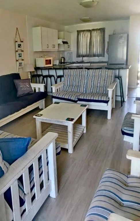 Open-plan lounge with striped sofa, armchair, and white coffee table