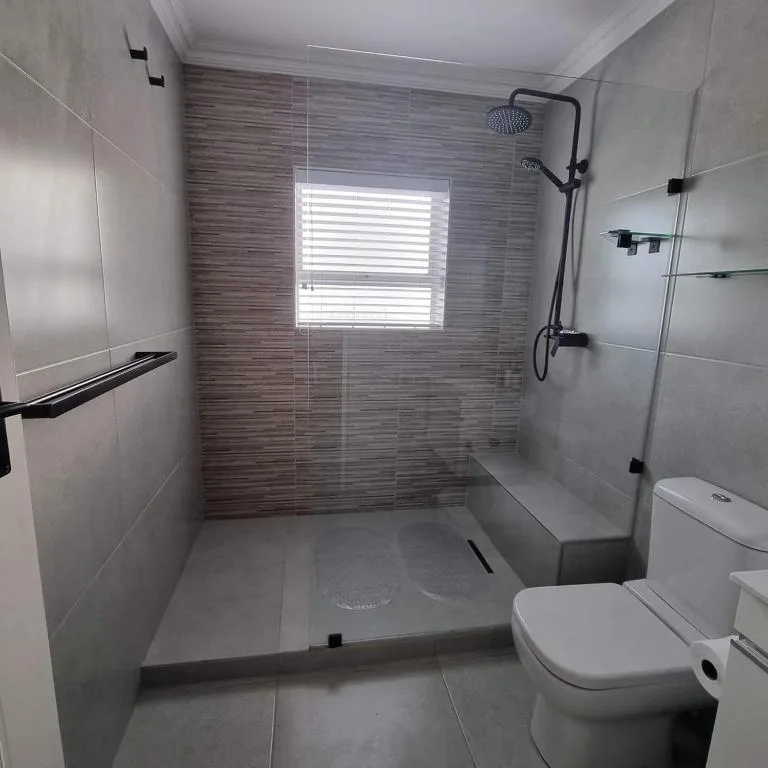 Modern bathroom with walk-in shower, glass enclosure, and contemporary fixtures