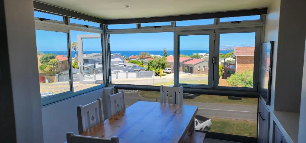 Ocean and coastal landscape views through expansive windows from dining area
