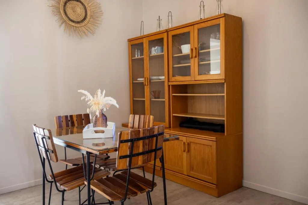 Wooden dining table with chairs and decorative cabinet display