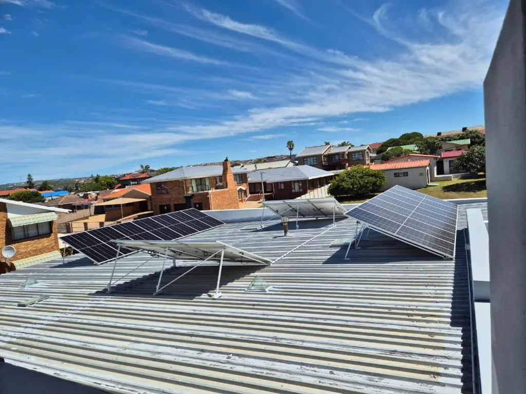 Rooftop view showing solar panels and corrugated metal roof structure