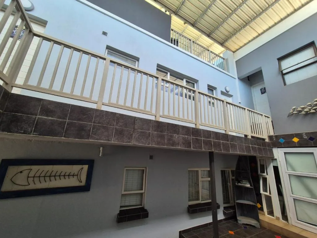 Modern aparthotel facade with upper deck railing and ground-level entrance doors