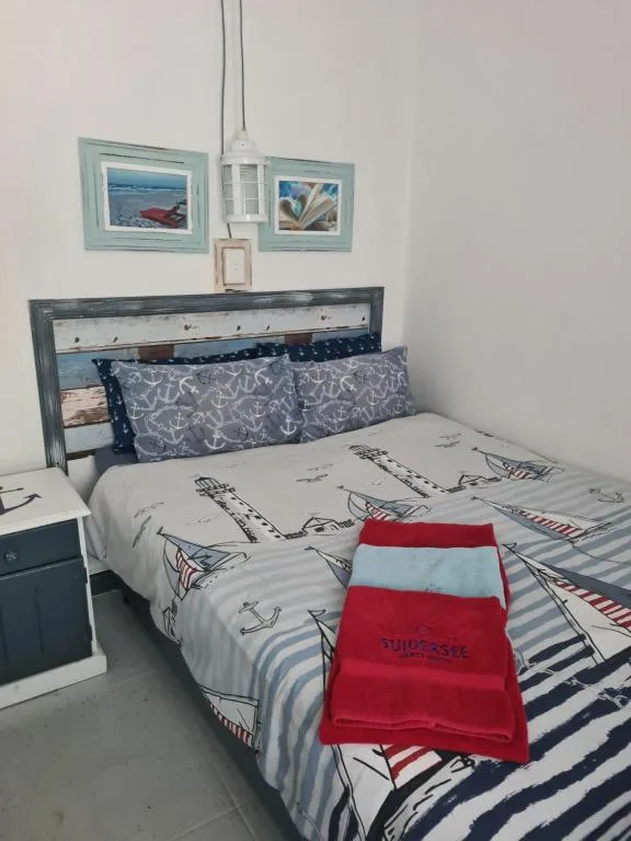 Nautical-themed bedroom with sailing boat bedding and anchor pillows