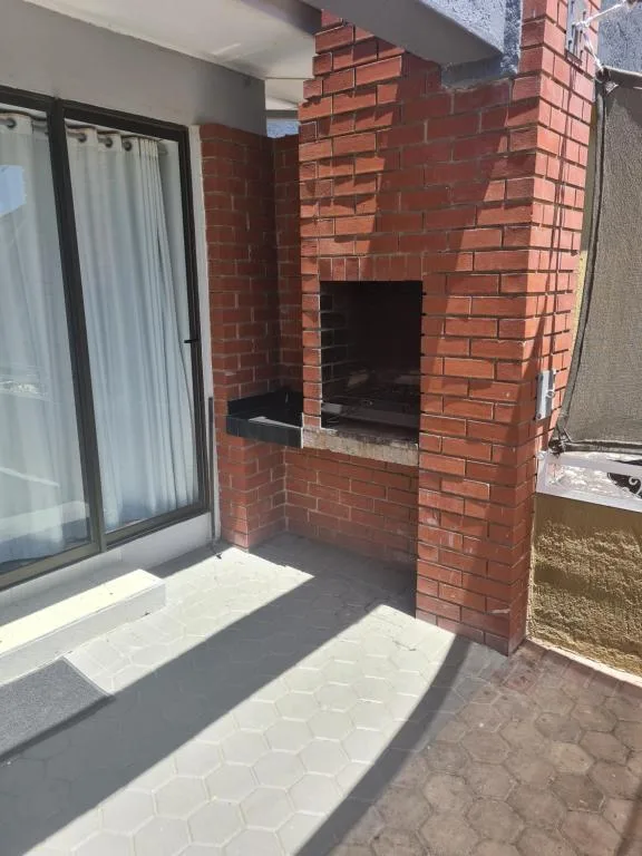 Outdoor patio with brick fireplace and sliding glass doors