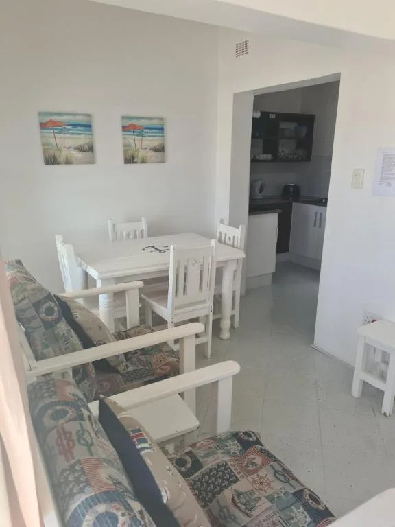 Open-plan dining and lounge area with white wooden table and chairs