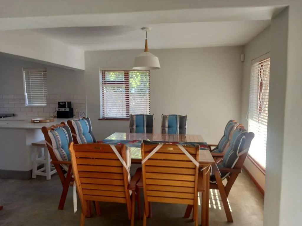 Spacious dining area with wooden table and striped upholstered chairs